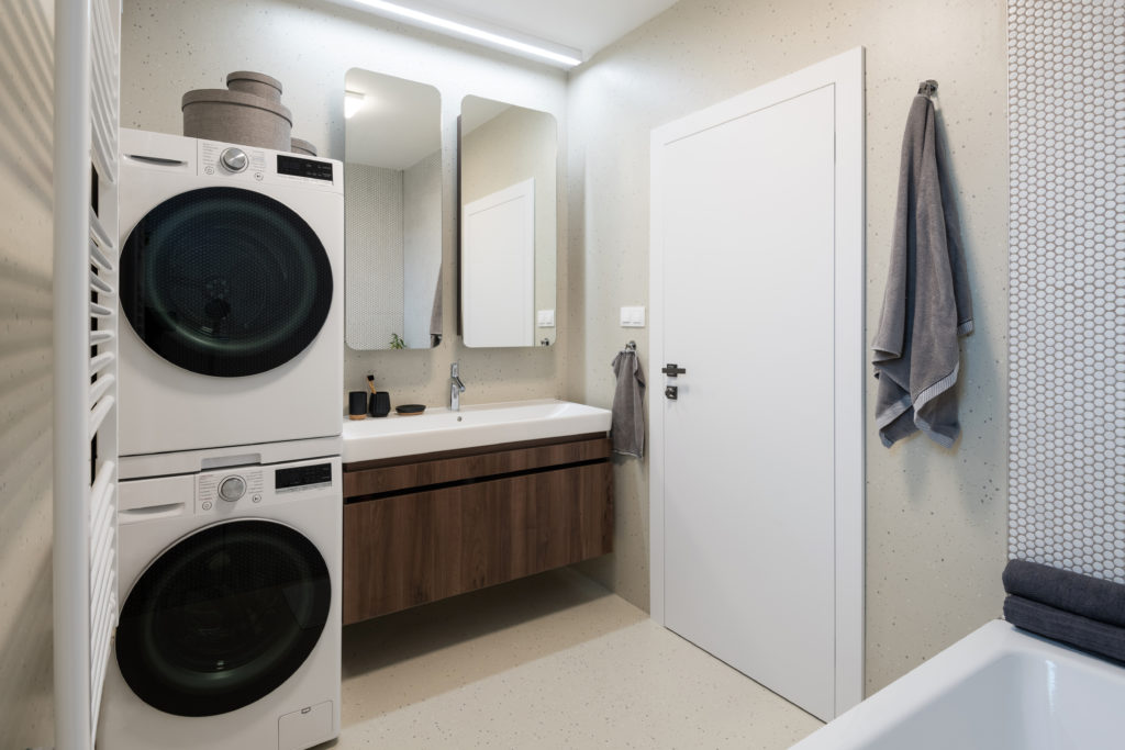 Interior of contemporary bathroom with washing machine and dryer
